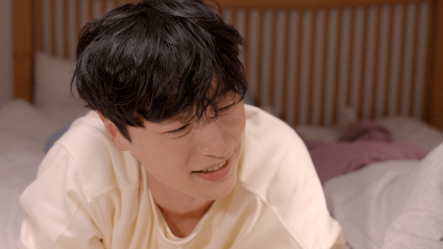 Young man smiling and talking on bed