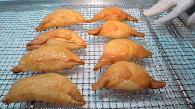 식힘망 위에 잘 줄지어진 튀긴 만두들