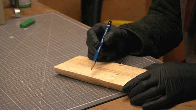 Woodcraft artisan marking wood with a pencil