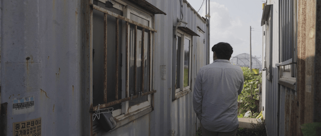 Man opening a door of a container building