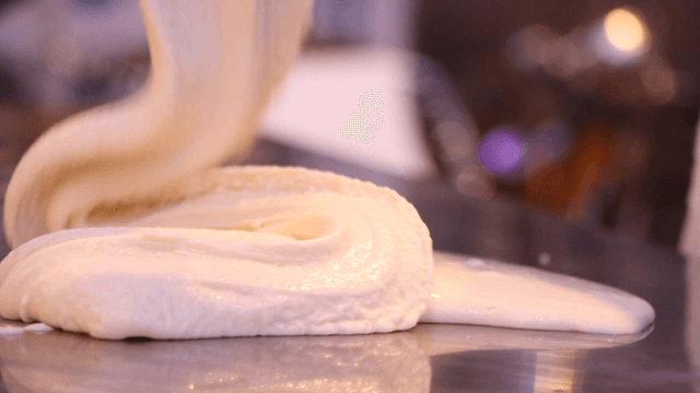 Dough being kneaded on a metal surface