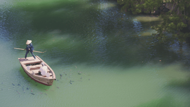 Two people on a boat in a green lake