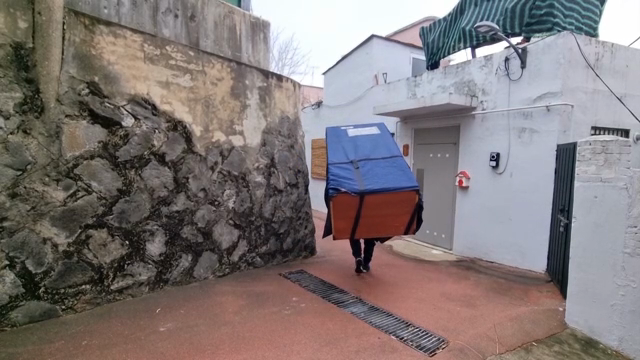 Person carrying a large object outdoors