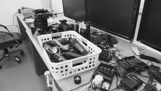 Desk cluttered with camera equipment