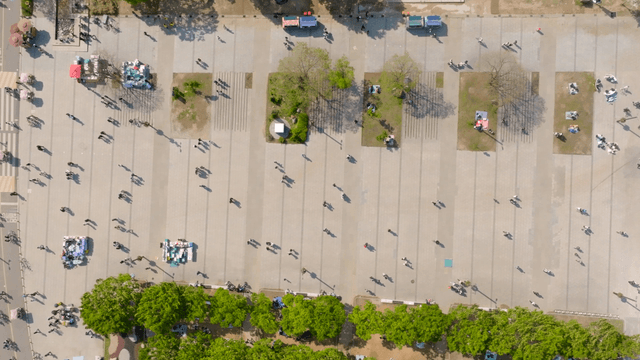 A bustling city square with people and cars