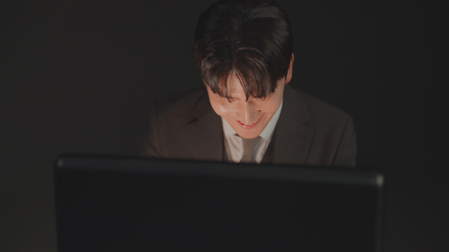 Man in a suit smiling as he opens a briefcase