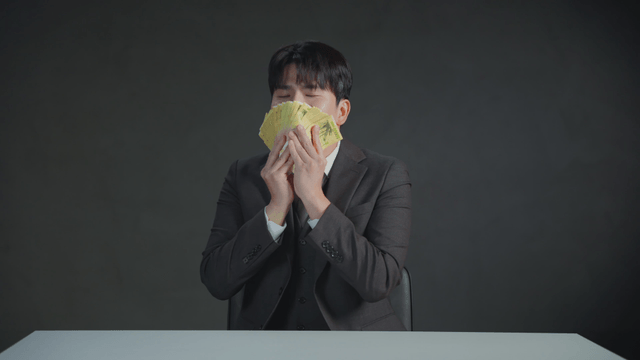 Man smelling money with a satisfied expression