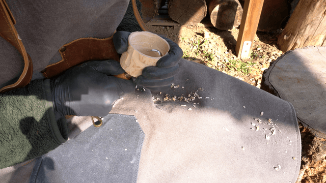 Wood carving with a chisel in sunlight outdoors