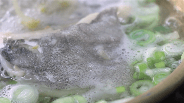 Cod soup boiling with green onions