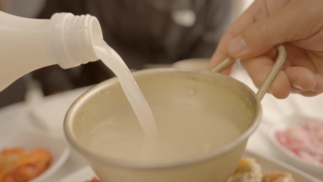 Pouring makgeolli into a traditional bowl