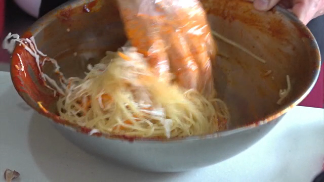 Mixing noodles with spicy sauce in a bowl