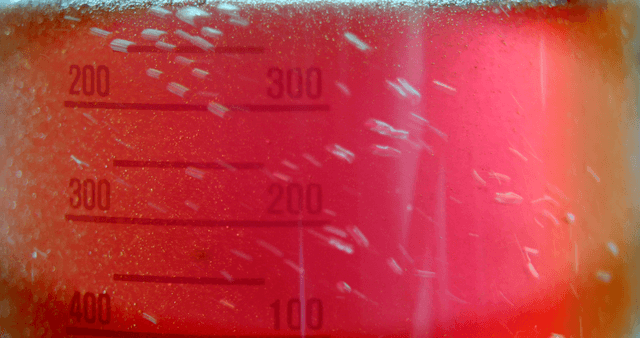 Red solution mixing and foaming inside a flask