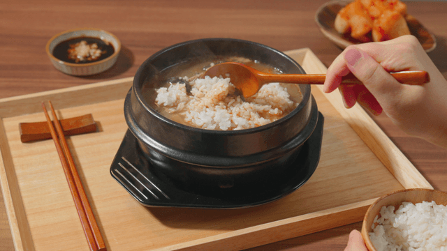 White rice being added to beef tripe soup