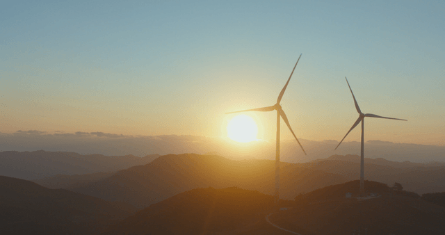 풍력 터빈 옆 산 위의 일출