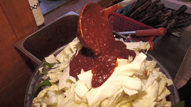 Plate of stir-fried chicken with cabbage and sauce added