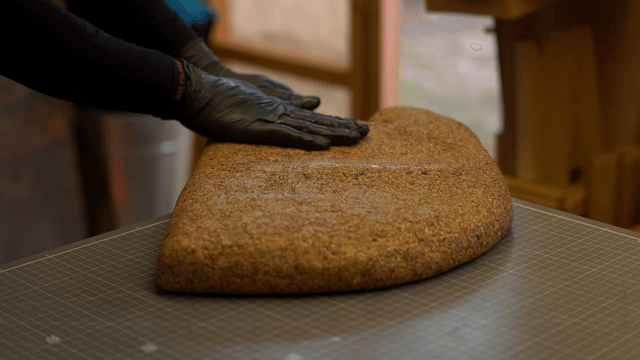 Artisan applying finishing solution evenly on cork sculpture
