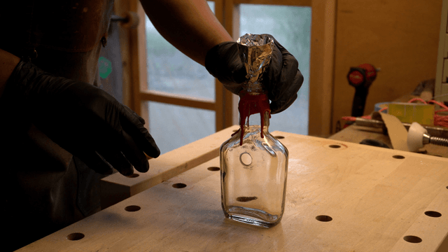 Person crafting with a glass bottle