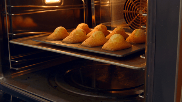 Freshly baked madeleines coming out of oven