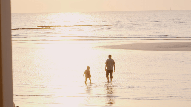 Father and child walking on the beach