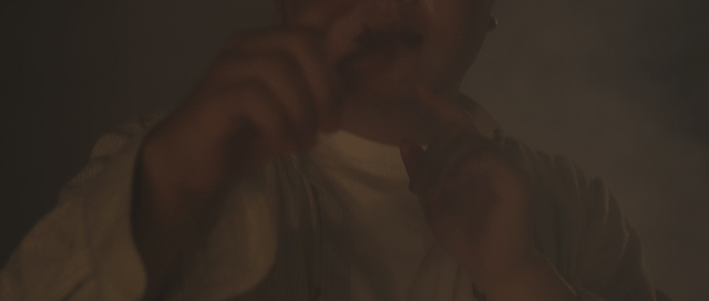 Man gesturing to take a photo in a dark place