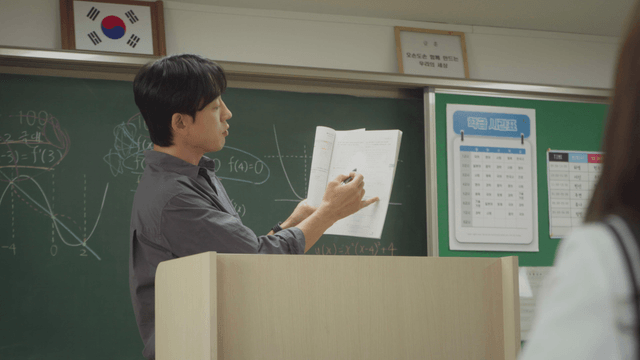 Teacher explaining math and answering questions in the classroom