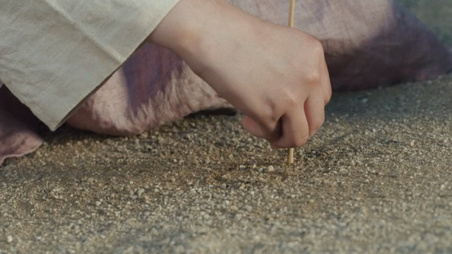 A hand drawing on sandy ground