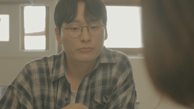 Man with glasses looking toward woman