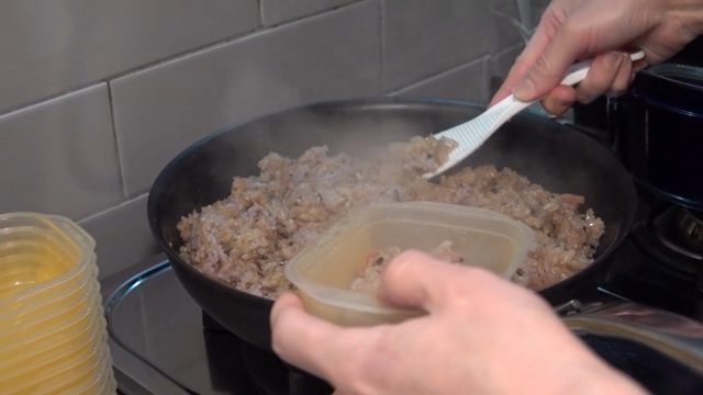 A scene of putting fried rice in a small container