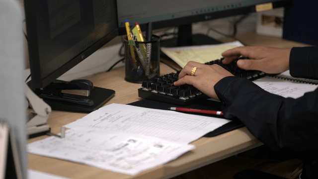 책상에서 키보드를 치는 사람