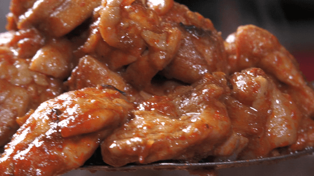 Spatula holding steaming stir-fried chicken