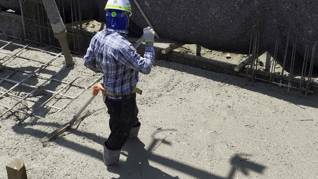 Worker smoothing concrete at a construction site