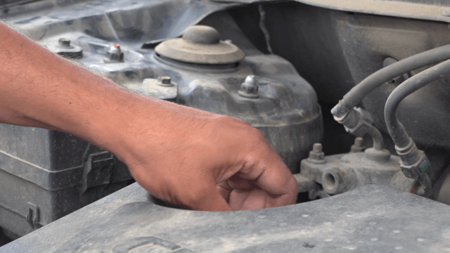 Inspection of dust-covered car engine oil cap