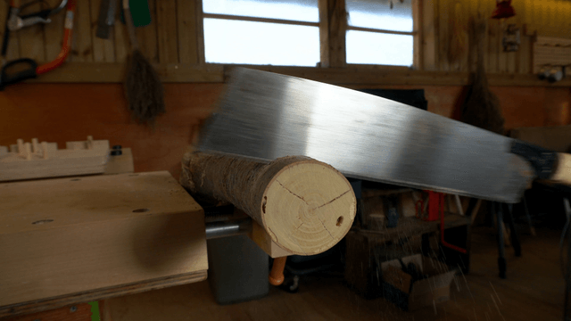 Saw cutting a wooden log in workshop