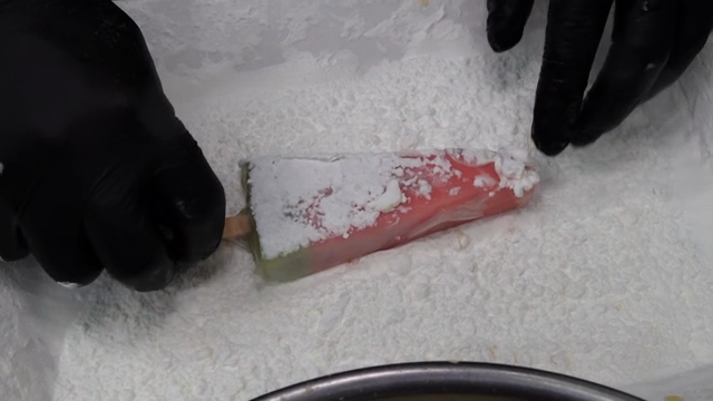 Coating a watermelon popsicle with frying powder