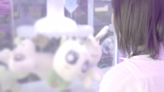 Person playing a claw machine in arcade