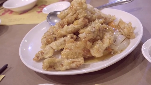 A plate of sweet and sour pork with onions