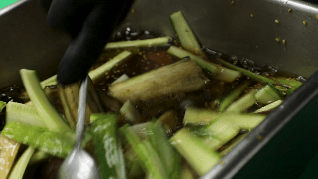 Spoon mixing cucumber and eggplant cold soup
