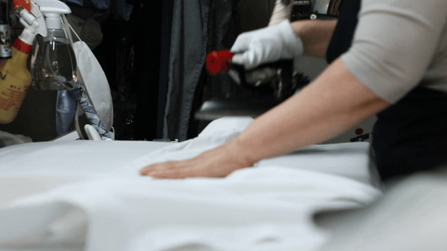 Person ironing clothes in a laundry shop