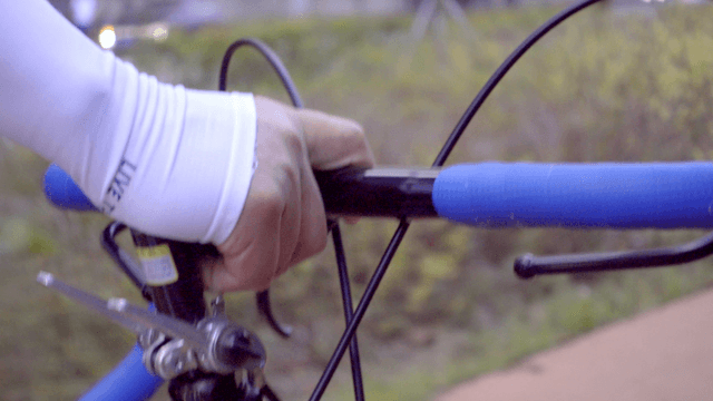 Cyclist gripping handlebars on a path