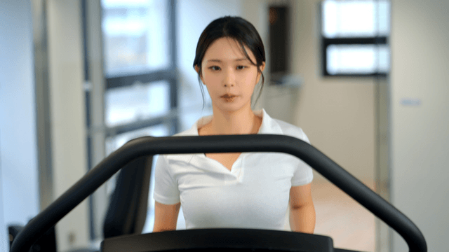 Woman jogging on a treadmill at gym
