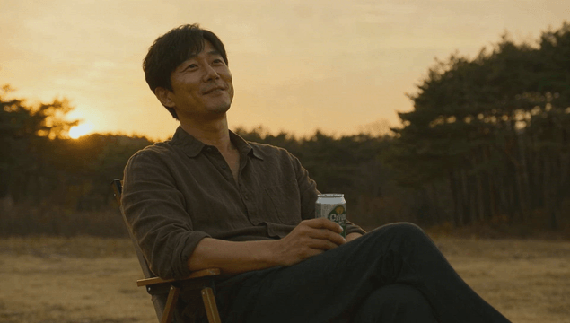 Man relaxing on camping chair holding beer can