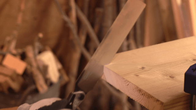 Cutting wood with a hand saw in a workshop