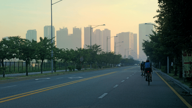 Cyclists riding on a city road at dawn