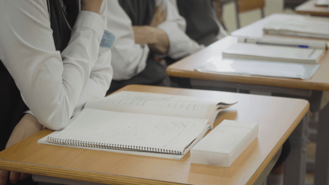 Students taking notes in the classroom with doodles in their notebooks