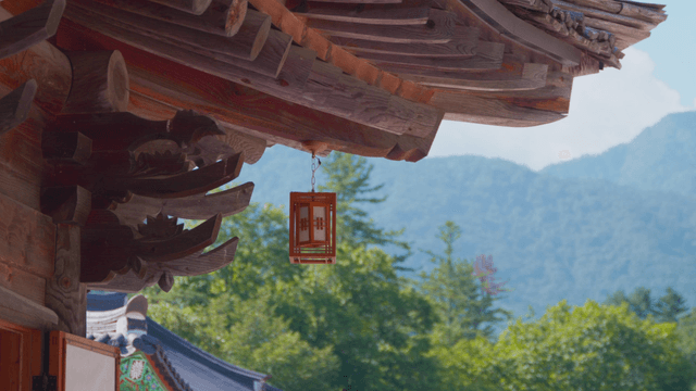 Traditional Korean house with lanterns against mountain backdrop