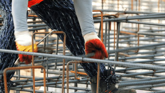 Worker assembling steel bars at a construction site