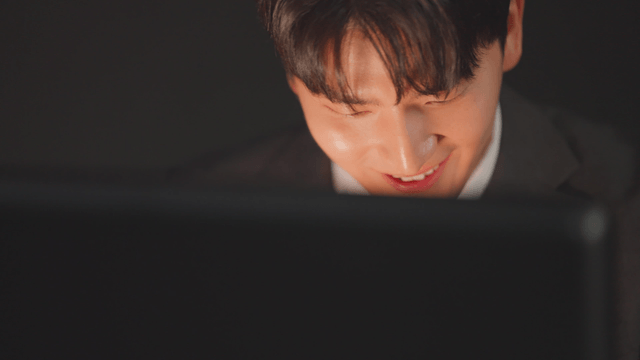 서류 가방을 열자 미소 짓는 정장을 입은 남자