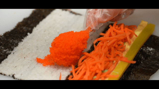 Preparing kimbap with fish roe and vegetables