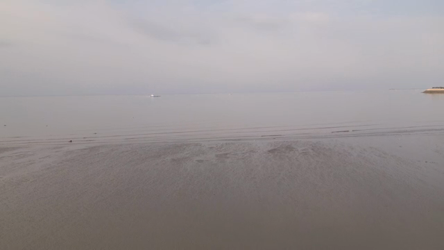 A tranquil beach with distant horizon