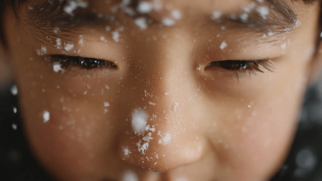 Child's face covered in snowflakes